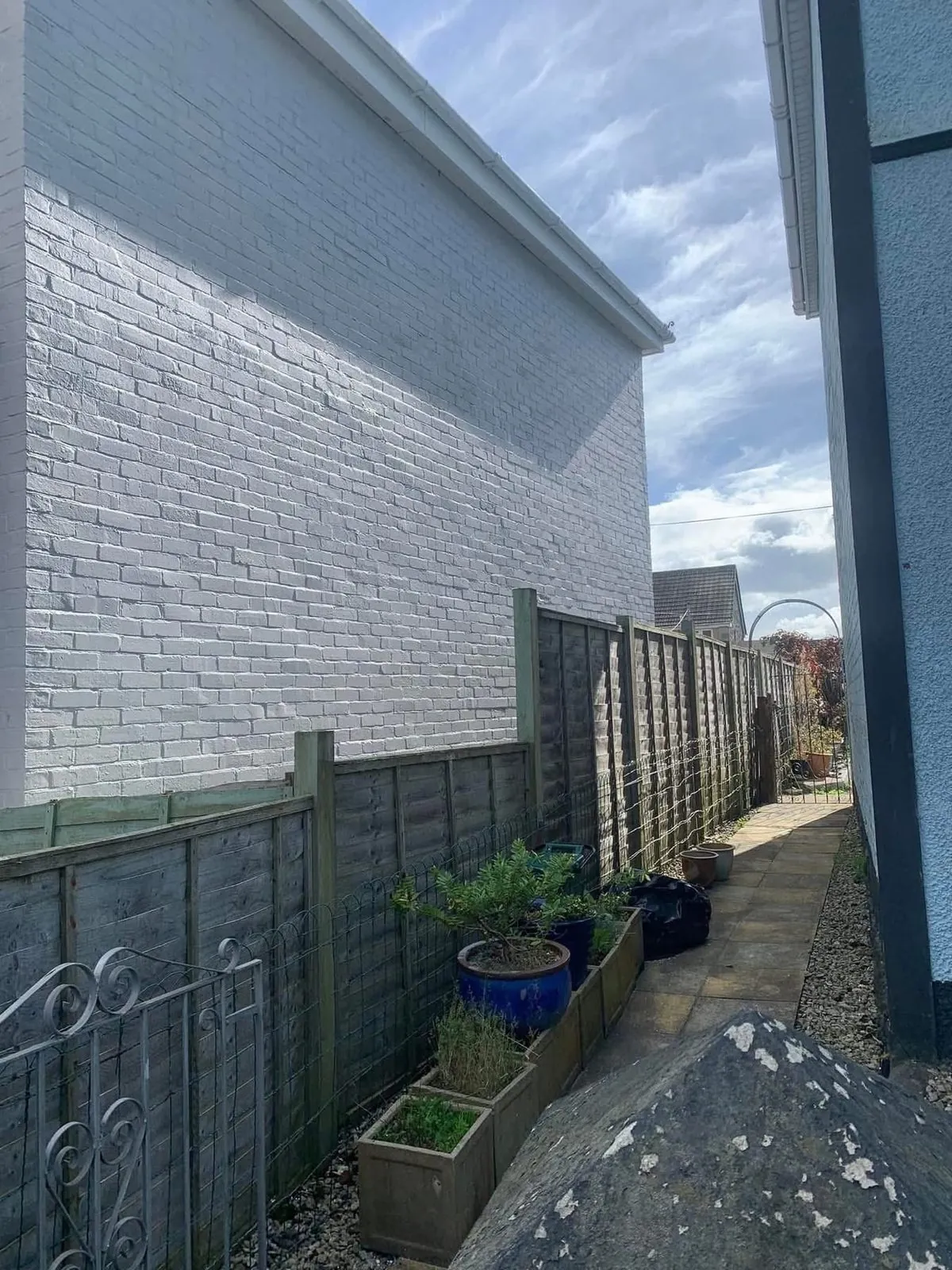 Freshly painted brick wall after preparation and masonry paint in St Blazey